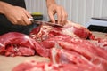 Butcher cutting fresh raw meat on counter Royalty Free Stock Photo