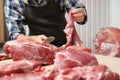 Butcher cutting fresh raw meat on counter Royalty Free Stock Photo
