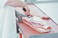 Butcher cutting meat for further processing with knife Royalty Free Stock Photo