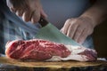Butcher cutting a piece of meat with a cleaver Royalty Free Stock Photo