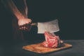Butcher cutting raw meat with cleaver Royalty Free Stock Photo