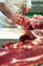 Butcher cutting up raw meat in a butchery Royalty Free Stock Photo