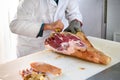 Butcher deboning a leg of prosciutto ham