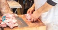 Meat concept. Butcher hands are cutting with cleaver ribs of lamb, sheep