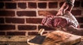 Butcher man hands holding raw beef steak in butchery