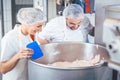 Butcher man and woman working together mincing meat