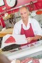 Butcher showing steak to customer