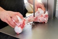 Butcher slicing a calf femur on a band saw