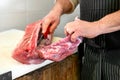 Butcher slicing a raw pork fillet off the bone