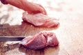 Butcher slicing raw pork fillet,