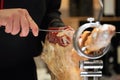 Butcher slicing slices of a spanish serrano ham