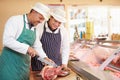 Butcher Teaching Apprentice How To Prepare Meat Royalty Free Stock Photo