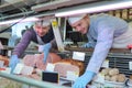 Butcher teaching young one how to sell meat