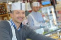 Butcher teaching young one how to sell meat