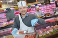 Butcher teaching young one how to sell meat