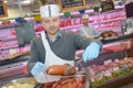 Butcher teaching young one how to sell meat