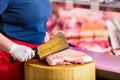 Butcher woman chopping meat on a block