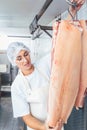 Butcher woman cutting meat for further use