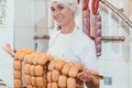 Butcher woman showing sausages on a rail