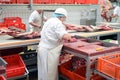 Butcher works in a slaughterhouse and cuts freshly slaughtered m