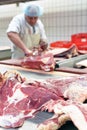 Butcher works in a slaughterhouse and cuts freshly slaughtered m