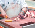 Butcher works in a slaughterhouse and cuts freshly slaughtered m