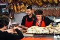 Butchers attending a customer in a butcher`s shop