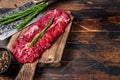 Butchers choice raw steak Onglet Hanging Tender beef meat on a cutting board. Dark wooden background. Top view. Copy space