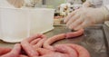 Butchers making sausage from mincer