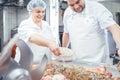 Butchers putting spices in minced meat