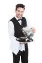 Butler lifting cloche from serving tray