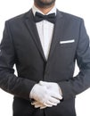 Butler, waiter with tuxedo and bow tie, folded gloved hands ready to serve, standing on white background