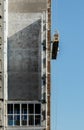 High-rise building under construction against a blue sky, an external elevator moves along the facade Royalty Free Stock Photo