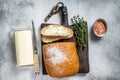 Butter block and sliced toasts of bread on a wooden board with herbs. White background. Top view Royalty Free Stock Photo