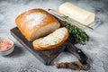 Butter block and sliced toasts of bread on a wooden board with herbs. White background. Top view Royalty Free Stock Photo