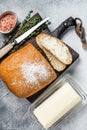 Butter block and sliced toasts of bread on a wooden board with herbs. White background. Top view Royalty Free Stock Photo