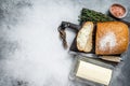 Butter block and sliced toasts of bread on a wooden board with herbs. White background. Top view. Copy space Royalty Free Stock Photo