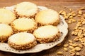 Butter cookies (alfajores) with caramel and peanuts on wooden background. Royalty Free Stock Photo