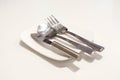 Butter knife, fork and spoon on a white plate Royalty Free Stock Photo