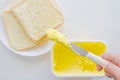 Butter Margarine on knife with two slices of bread on the table. Royalty Free Stock Photo