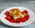 Butter omelet with sliced red tomatoes on a white plate Royalty Free Stock Photo