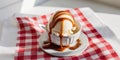 Butter pecan ice cream with caramel drizzle on classic red checkered tablecloth. Royalty Free Stock Photo