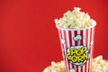 Butter popcorn in a red popcorn cup, snack in the house or cinema on a red background Royalty Free Stock Photo