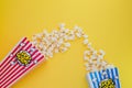 Butter popcorn in a red popcorn cup, snack in the house or cinema on a yellow background Royalty Free Stock Photo