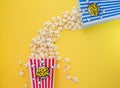 Butter popcorn in a red popcorn cup, snack in the house or cinema on a yellow background Royalty Free Stock Photo