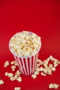 Butter popcorn in a red popcorn cup, snack in the house or cinema on a red background Royalty Free Stock Photo