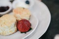 Butter scones served with jam and clotted cream with strawberries on white plate.Breakfast, Traditional English Afternoon Tea, Royalty Free Stock Photo