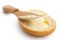Butter spread on a half of crusty bread roll with a wooden knife Royalty Free Stock Photo