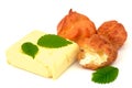 Butter, spread, margarine, oil, bar, pack, piece, block with baked eclair, custard, cake and green leaf, parsley, greens. Isolated