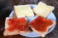 Buttered bread and strawberry jam on tableware Royalty Free Stock Photo